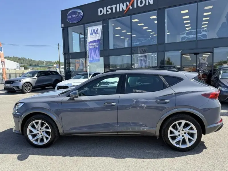 Vue de profil côté gauche d'un CUPRA Formentor gris 2023 hybride essence, avec jantes alliage et toit noir contrasté.