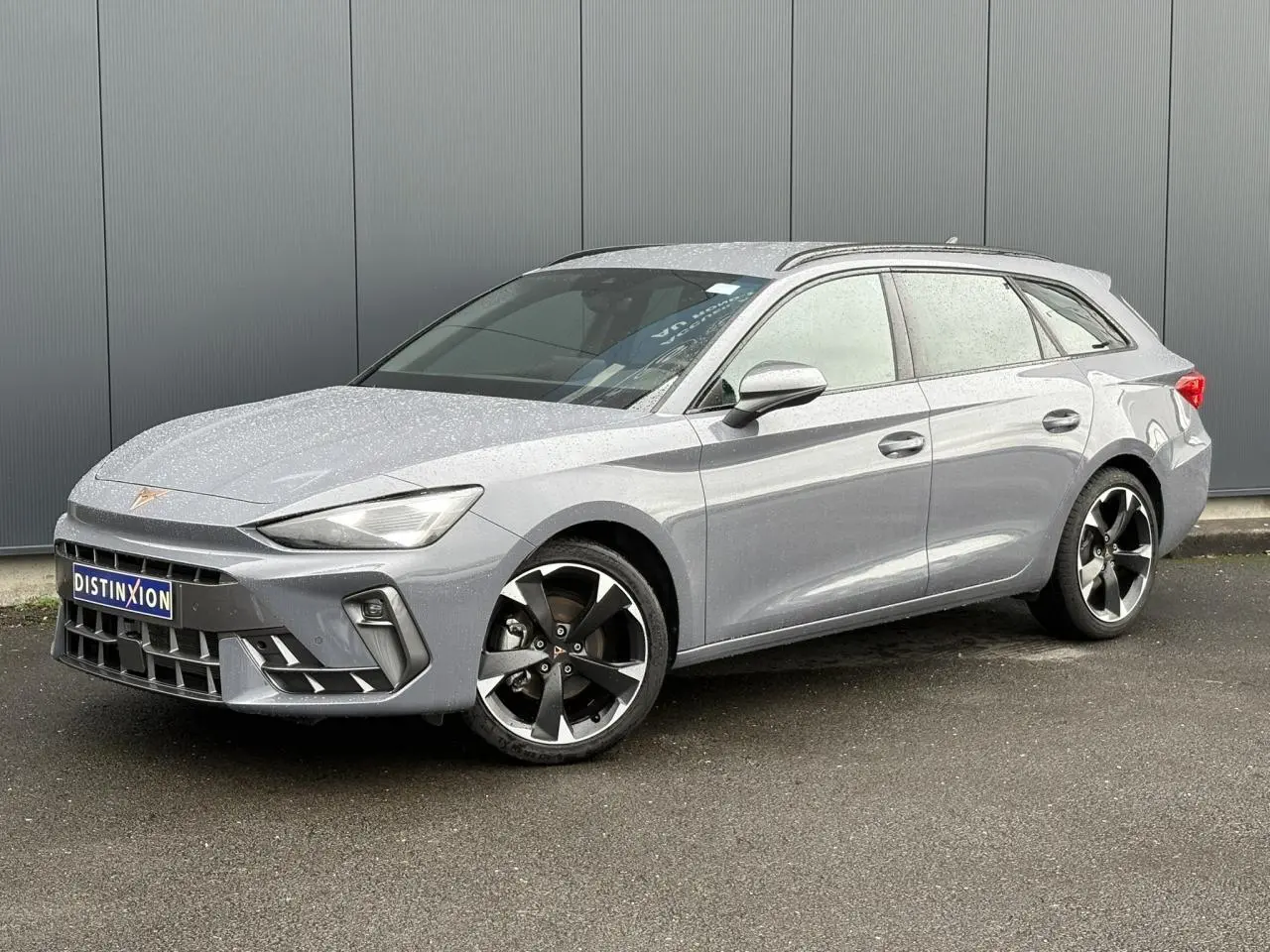 Vue 3/4 avant droite du CUPRA LEON ST 2025 en Gris Graphene avec jantes alliage et signature lumineuse avant.