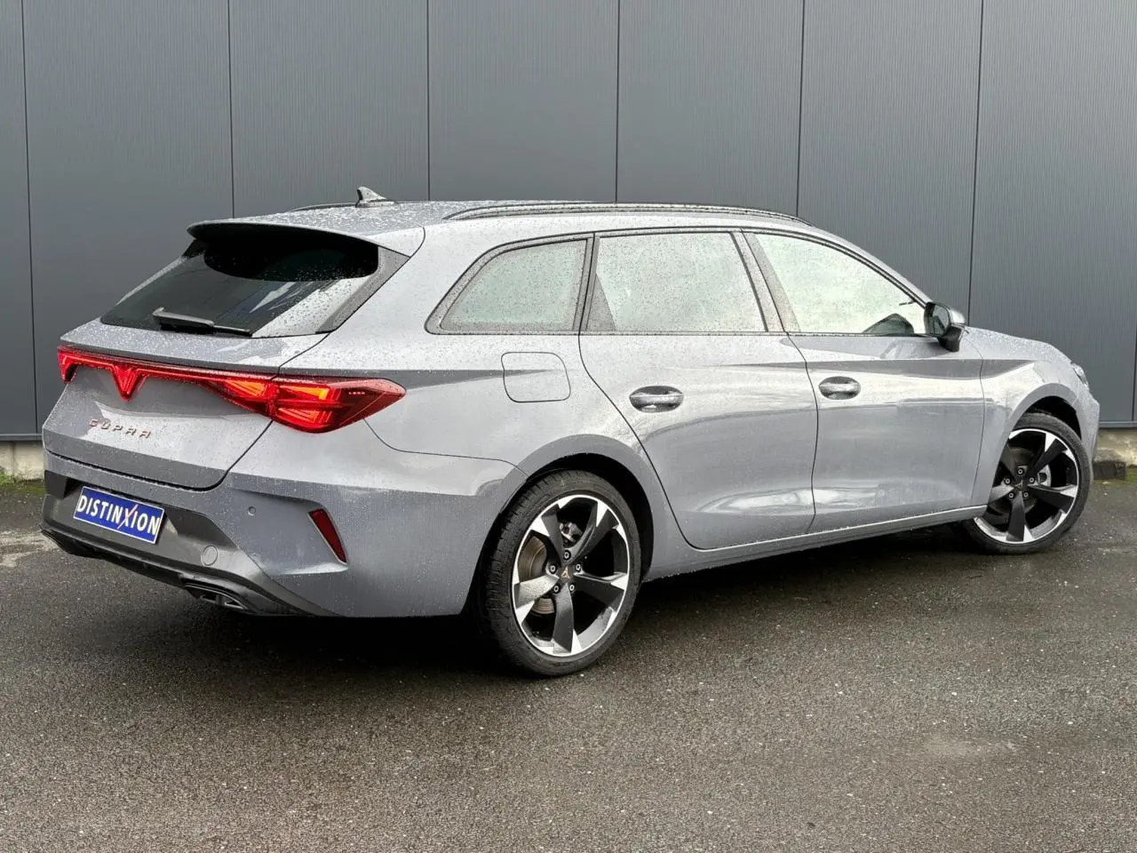 Vue 3/4 arrière droite d'une CUPRA LEON ST gris Graphene avec feux arrière Tri-LED et jantes alliage 18 pouces.