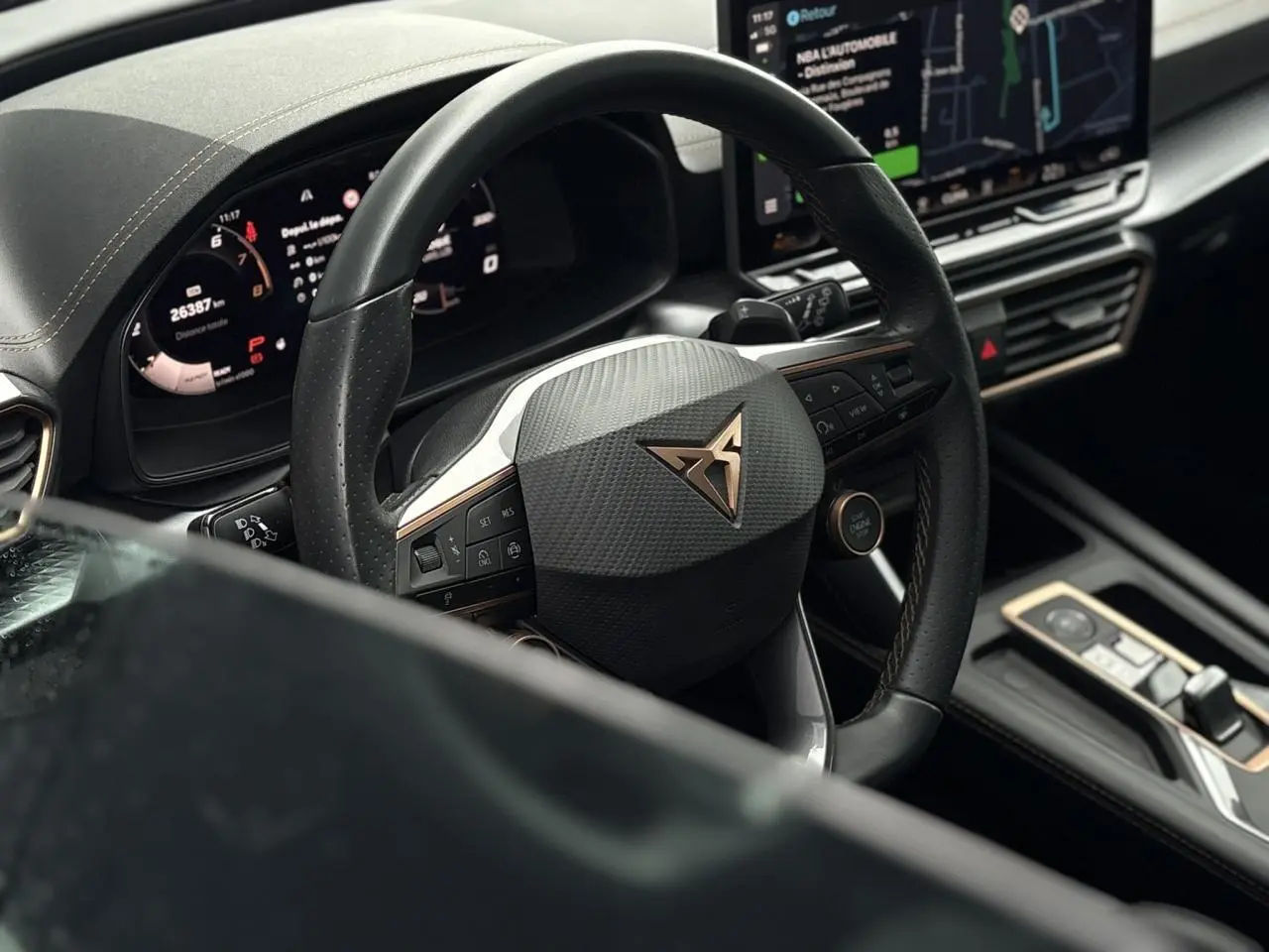 Vue rapprochée du volant cuir noir perforé avec logo CUPRA et tableau de bord digital du Leon ST Gris Graphene 2025.