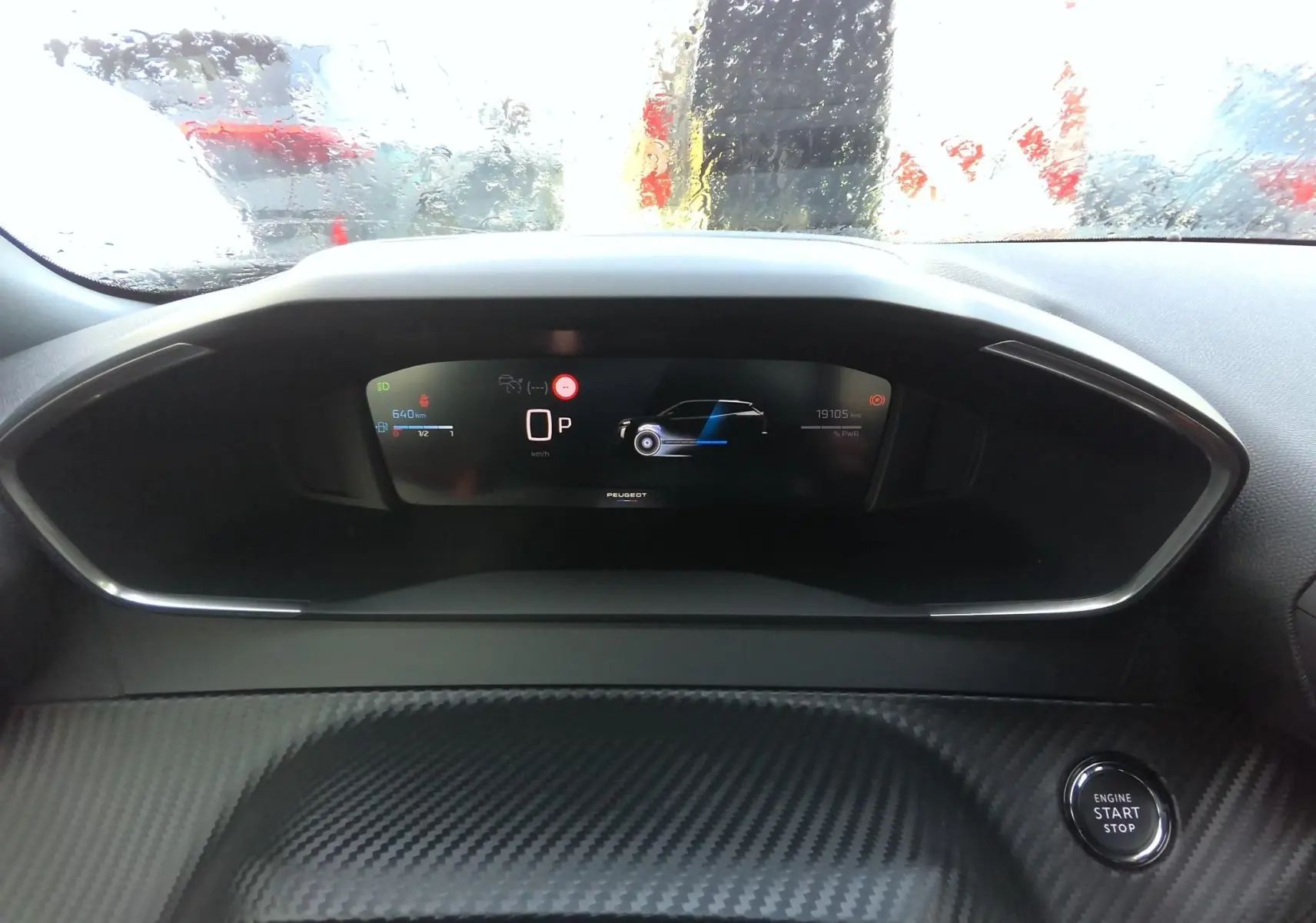 Tableau de bord numérique du Peugeot 2008 hybride, affichage central avec compteur et bouton start/stop visible.