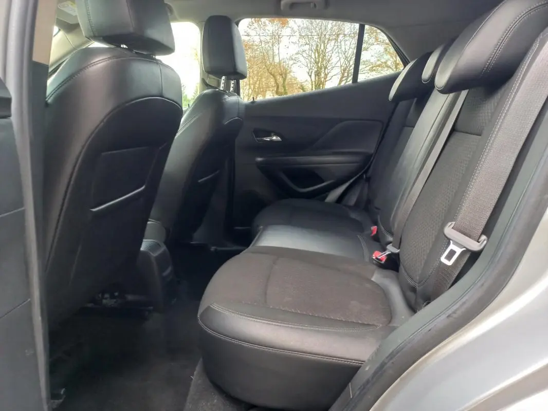 Vue intérieure côté droit sur les sièges arrière noirs de l'Opel Mokka X gris 2017, version 1.4 Turbo Innovation.