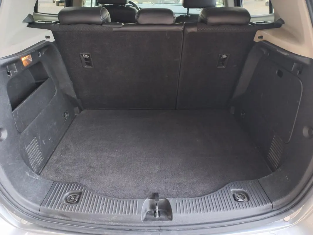 Vue intérieure du coffre ouvert de l'Opel Mokka X gris 2017, montrant un espace de chargement propre et spacieux.