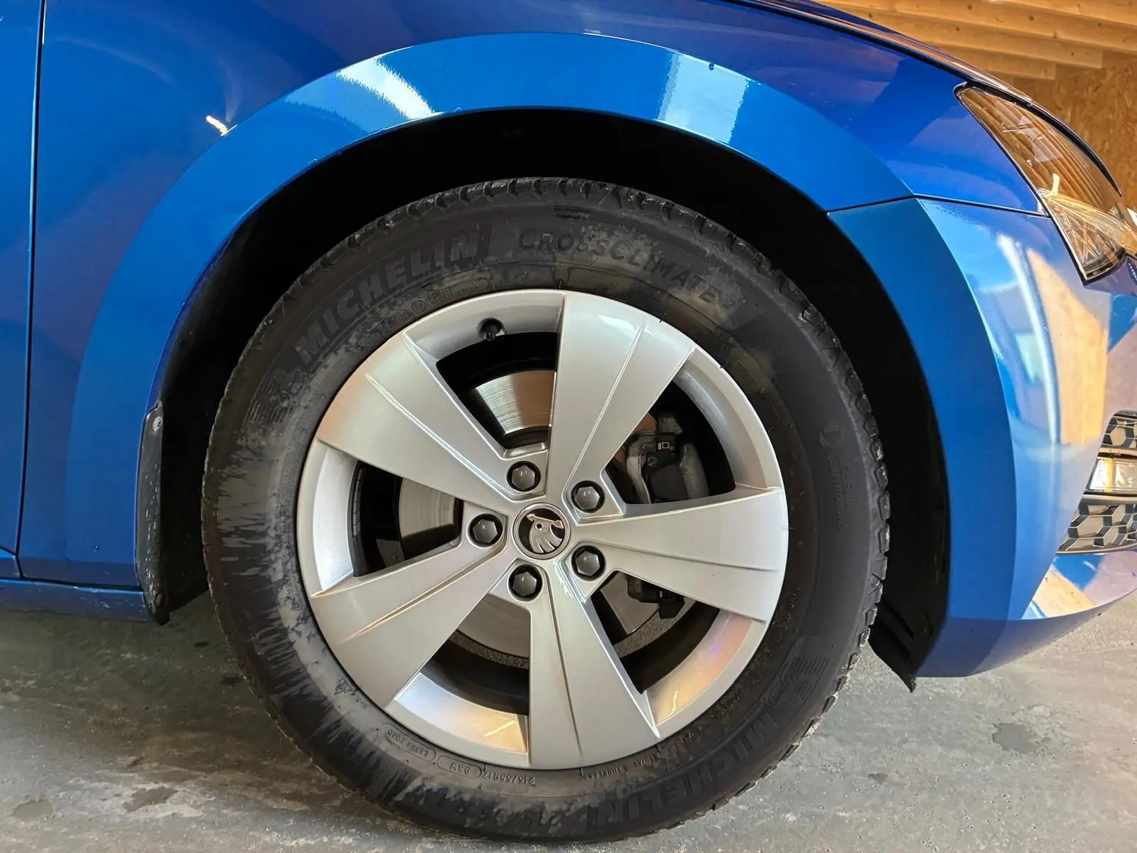 Gros plan sur la roue avant gauche d'une Skoda Superb Combi bleu 2021 avec jante alliage et pneu Michelin.