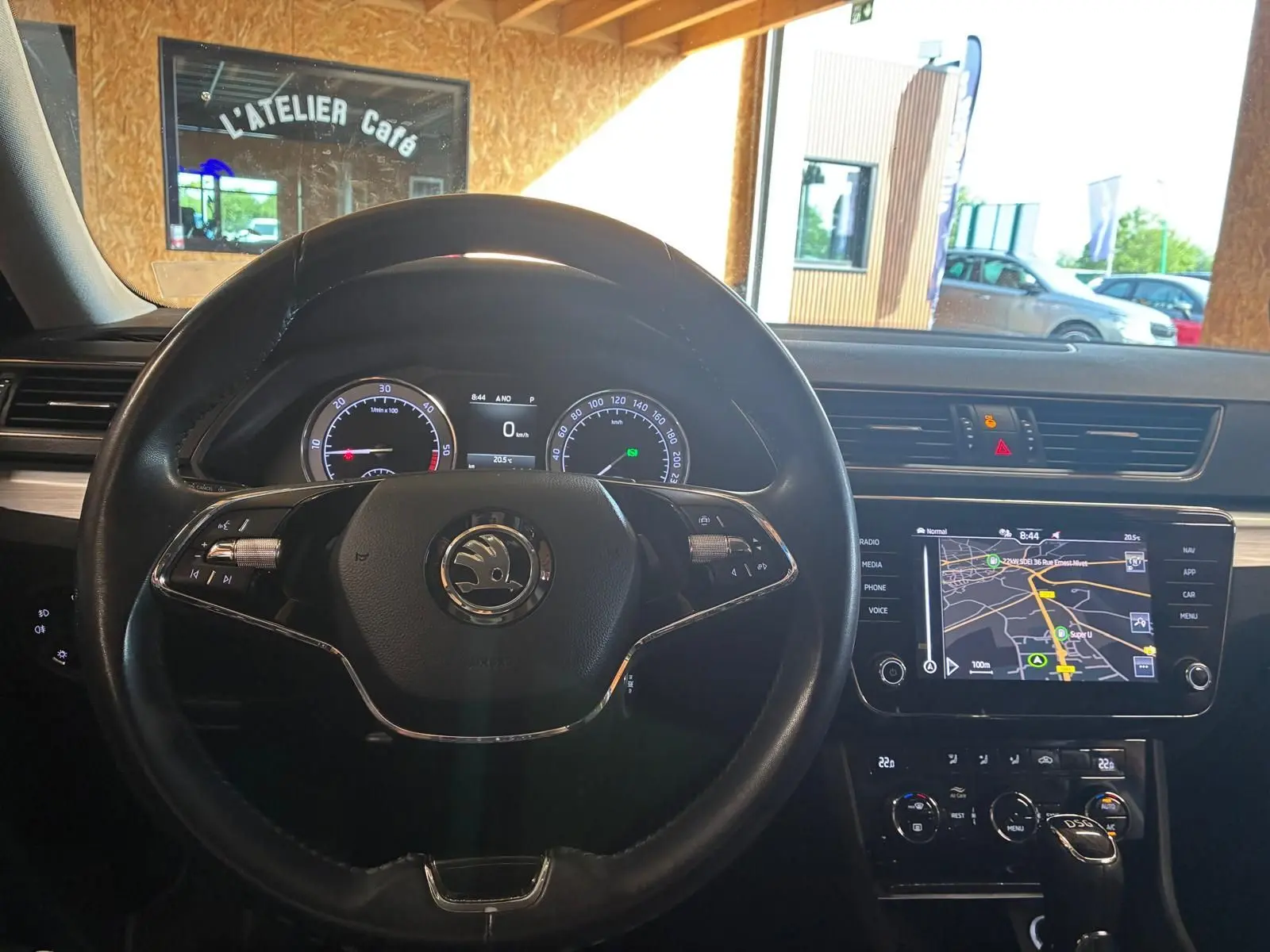 Vue intérieure centrée sur le volant noir et le tableau de bord avec écran GPS tactile de la Skoda Superb Combi 2021.