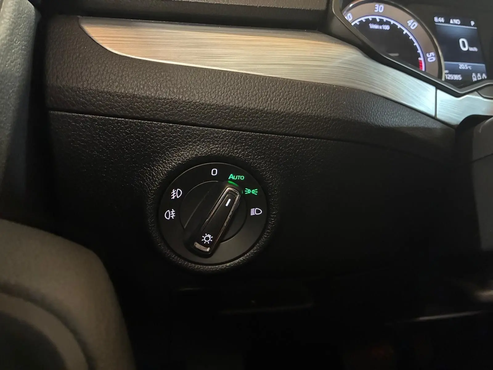 Gros plan sur le bouton de commande des phares avec tableau de bord partiel de la Skoda Superb Combi 2021 intérieur noir.