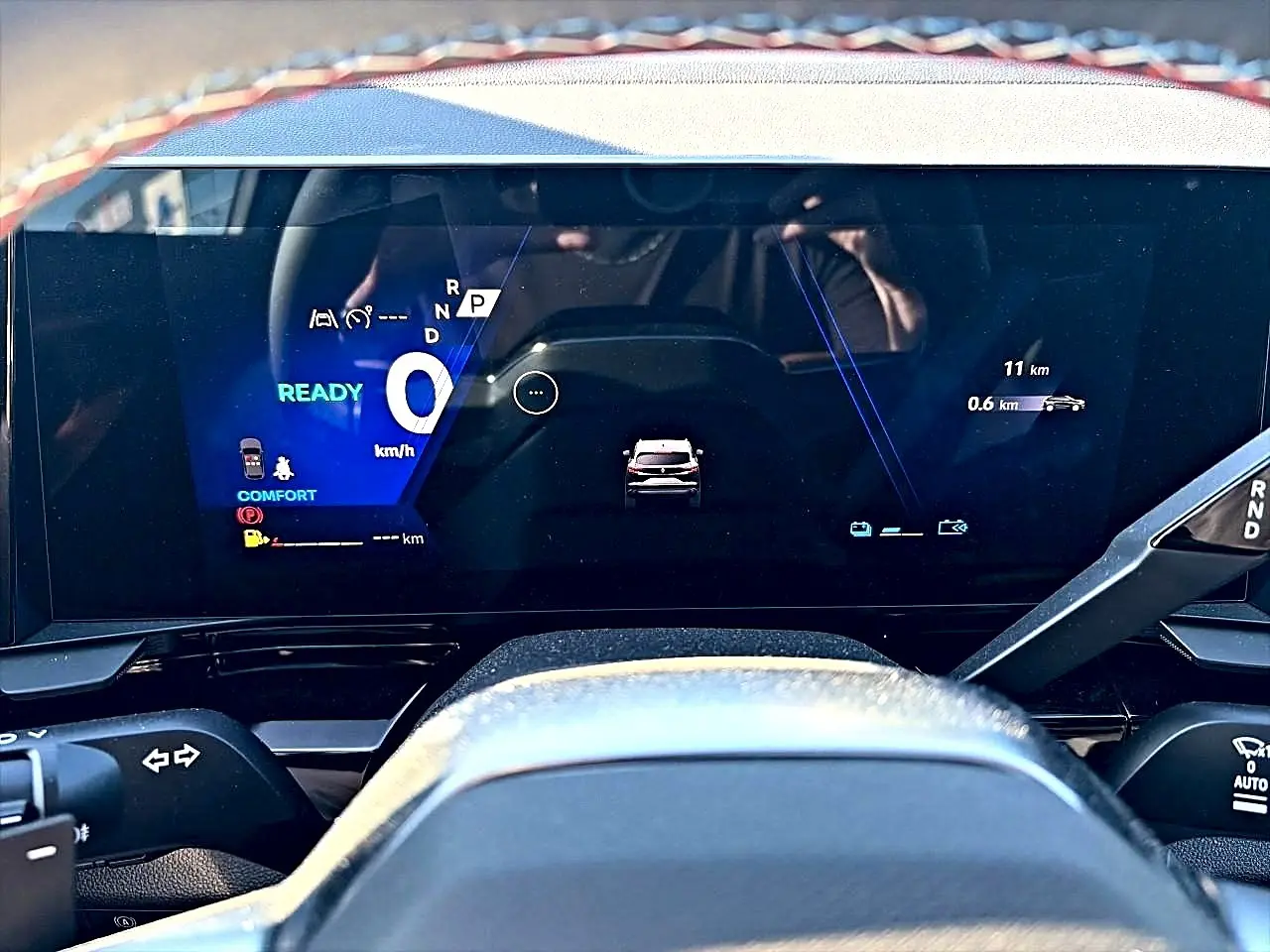 Vue rapprochée du tableau de bord numérique du Renault Austral 2026, affichage digital moderne avec indicateurs bleus et blancs.