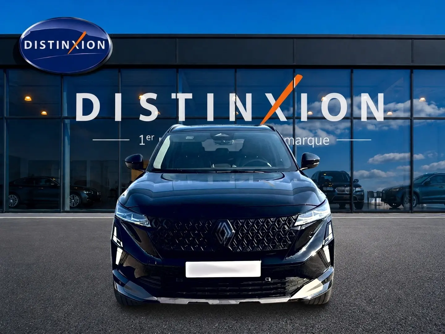 Vue avant d'un Renault Austral noir avec calandre distinctive et phares LED, devant une vitrine Distinxion.