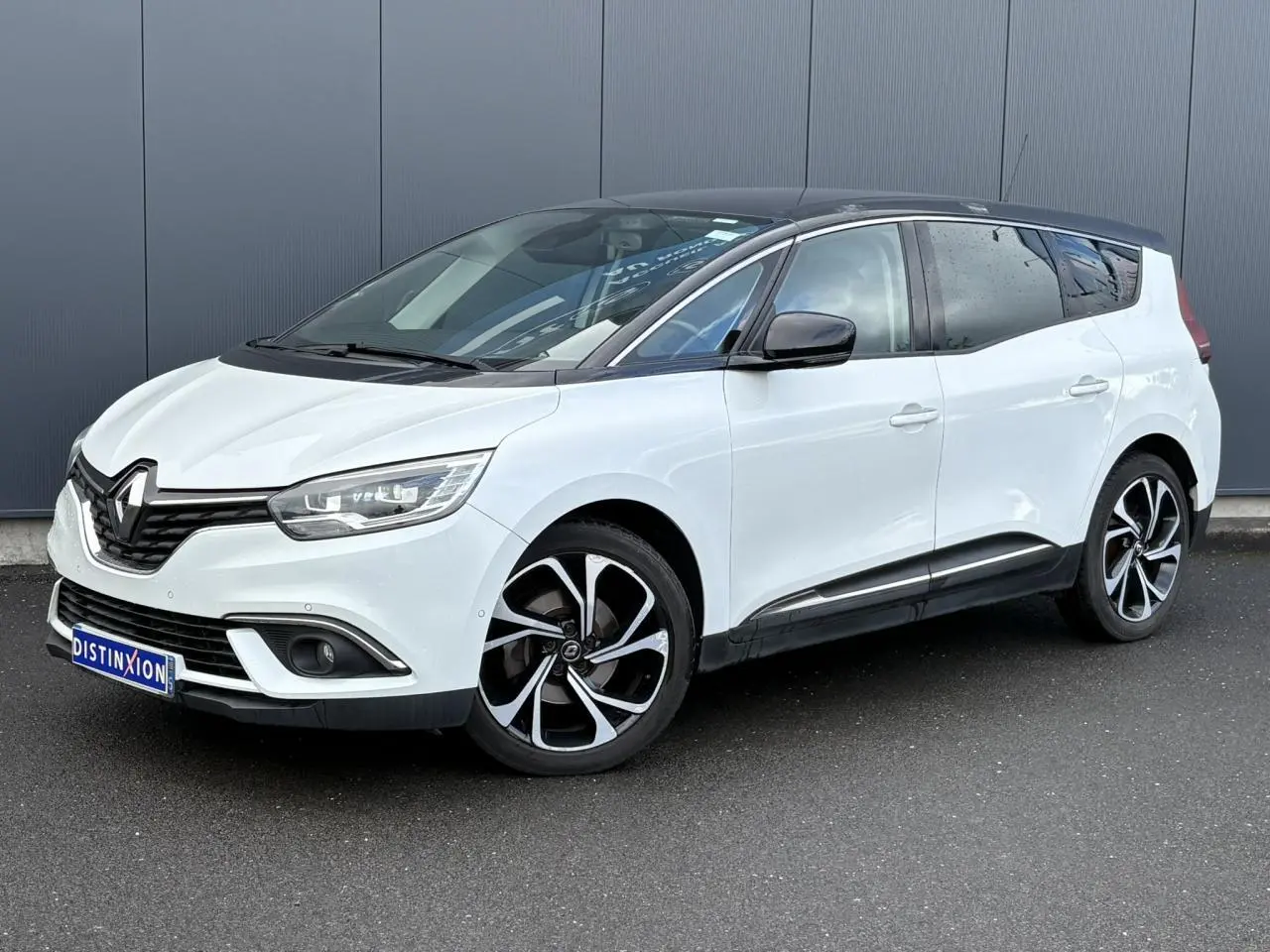Renault Grand Scenic blanc nacré vu de 3/4 avant droit avec toit noir étoilé et jantes alliage 20 pouces.