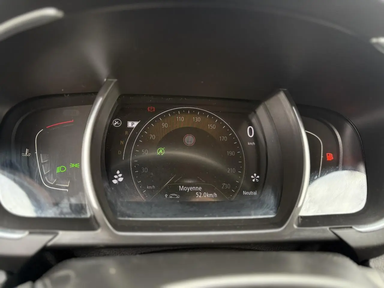 Tableau de bord numérique du Renault Grand Scenic IV, affichant 0 km/h et indicateurs de vitesse moyenne et feux allumés.