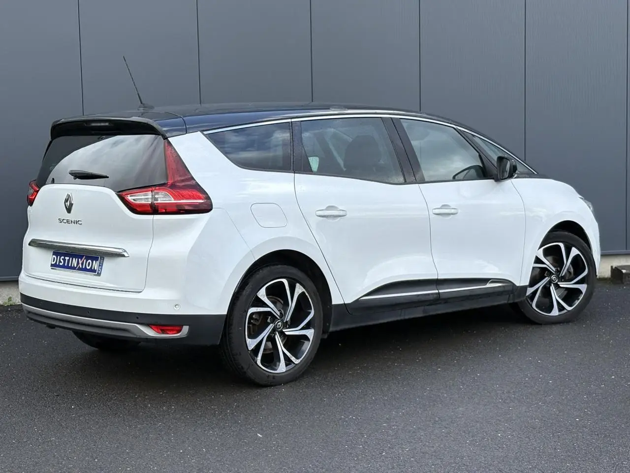 Renault Grand Scenic blanc nacré en 3/4 arrière droit avec toit noir étoilé et jantes alliage 20 pouces.