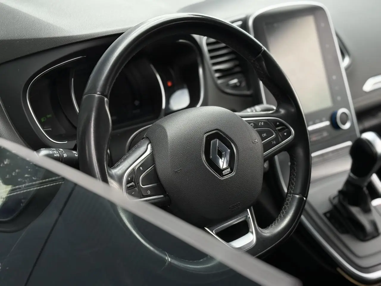 Volant cuir Renault avec logo au centre, tableau de bord et écran tactile vertical du Grand Scenic IV essence 2018.