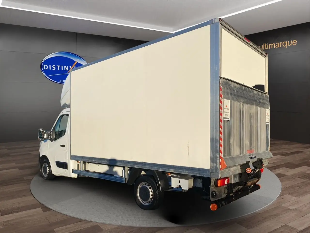 Renault Master blanc vu en 3/4 arrière droit avec caisse fermée et hayon élévateur métallique visible.