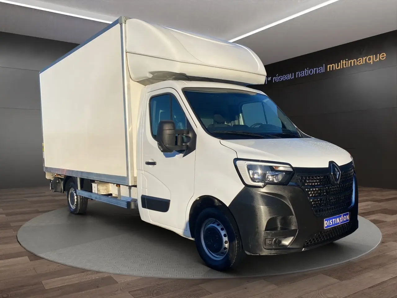 Renault Master blanc en 3/4 avant droit avec caisse hayon, calandre noire et jantes tôlées 16 pouces.