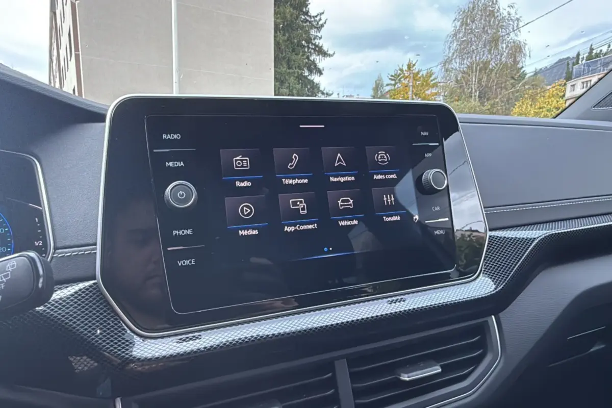 Écran tactile central du tableau de bord du Volkswagen T-Cross blanc pur 2025, avec interface multimédia visible.