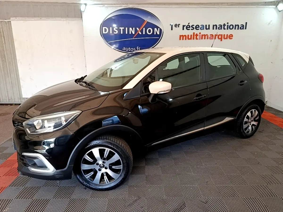 Renault Captur Business TCe 90 noir, vue 3/4 avant droit, avec rétroviseurs blancs et jantes alliage bicolores.