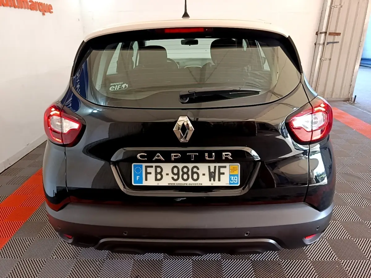 Vue arrière d'un Renault Captur noir 2018 avec feux arrière allumés et plaque d'immatriculation française visible.