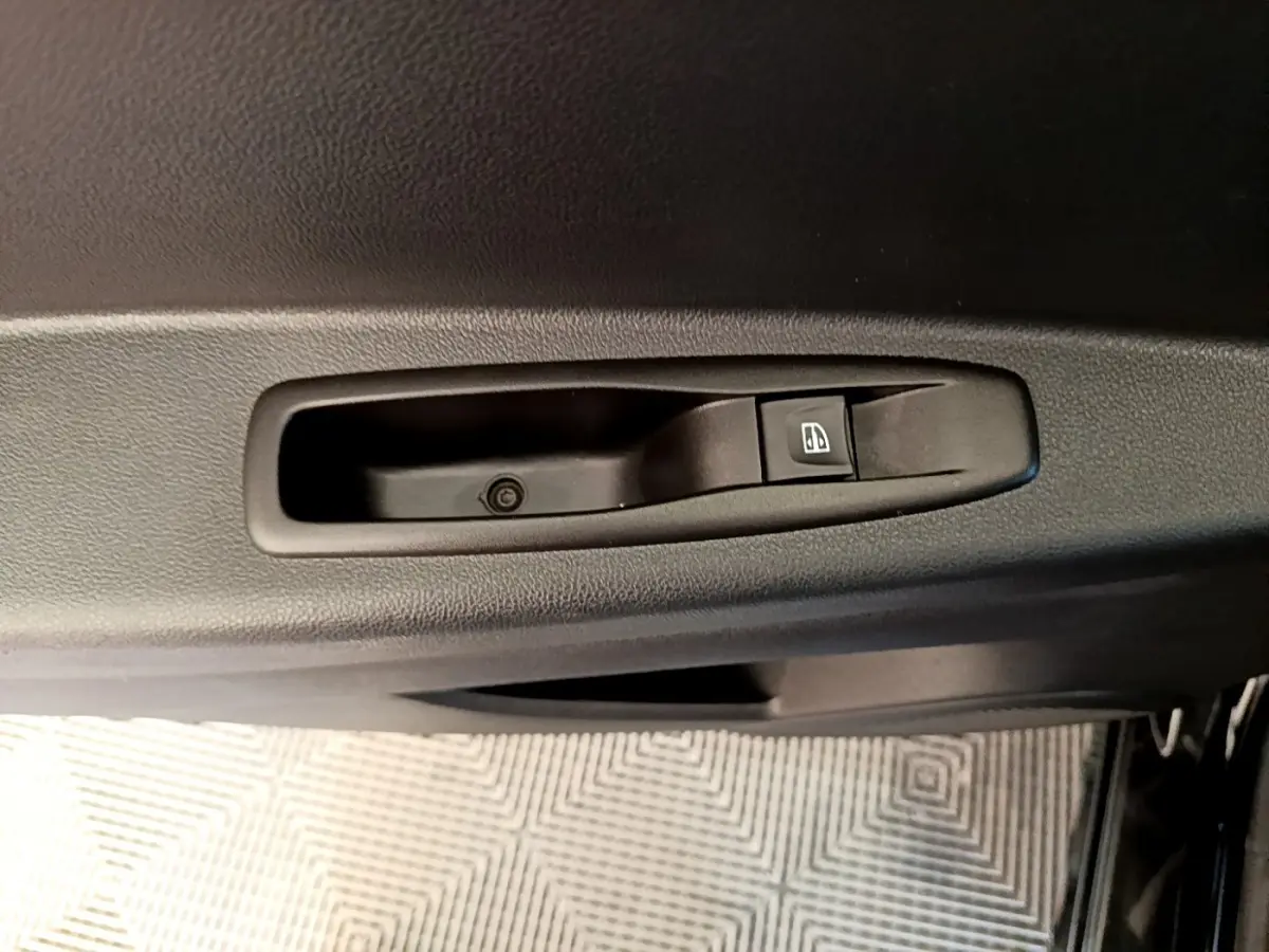 Gros plan sur le bouton de commande de la vitre électrique côté conducteur d’un Renault Captur noir 2018.