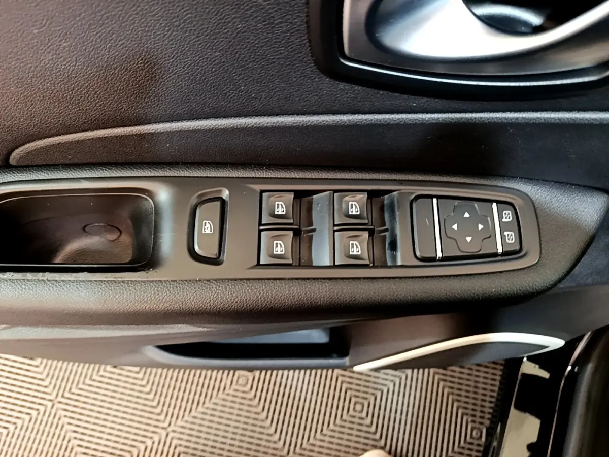 Vue rapprochée des commandes des vitres et des rétroviseurs sur la porte côté conducteur d’un Renault Captur noir 2018.