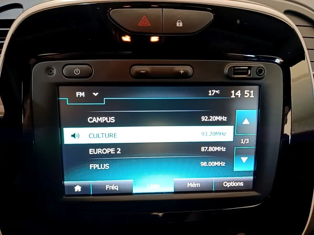 Écran tactile central du tableau de bord du Renault Captur Business noir, affichant les stations radio FM.