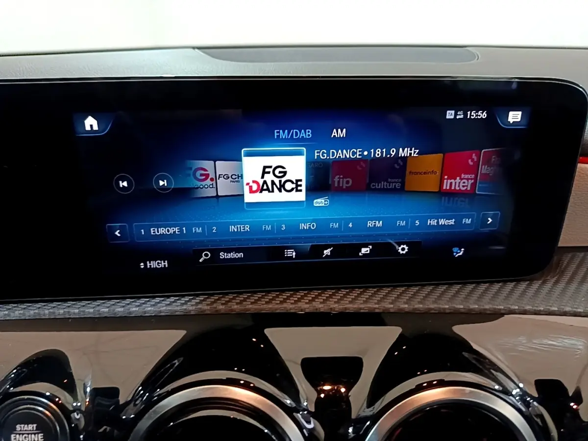Écran tactile central affichant la radio FM/DAB dans l’habitacle d’une Mercedes Classe A blanche, vue de face rapprochée.