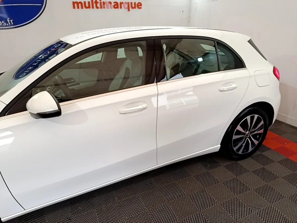 Vue latérale droite d'une Mercedes Classe A Berline blanche, avec rétroviseur électrique et jantes alliage distinctives.