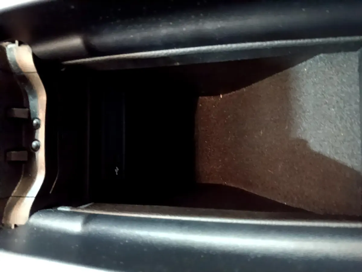 Vue rapprochée de la console centrale noire de la Mercedes Classe A 250 e Business Line 2020, avec compartiment de rangement.