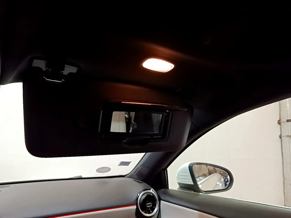 Intérieur de la Mercedes Classe A blanche, vue côté droit sur pare-soleil avec miroir éclairé et rétroviseur extérieur.