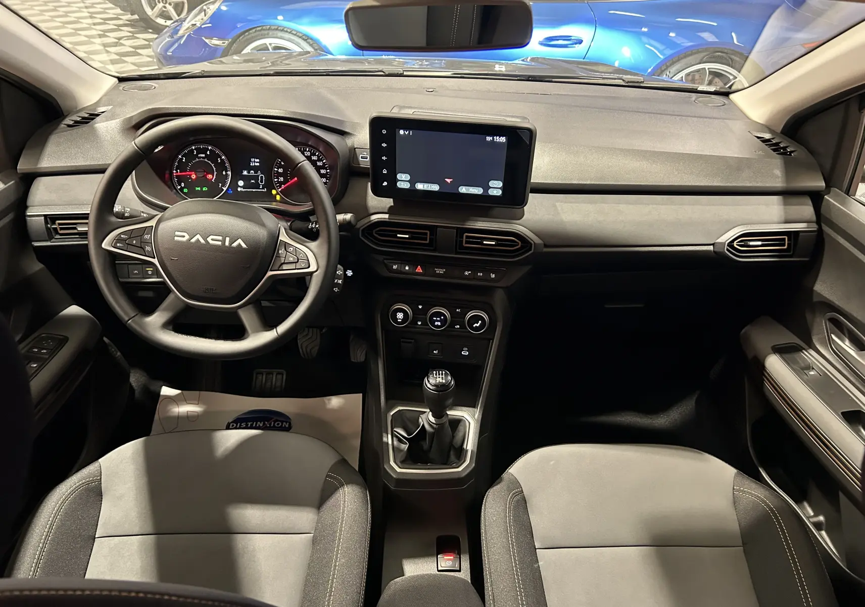 Vue intérieure avant du Dacia Jogger 2026 avec tableau de bord noir, écran tactile central et volant multifonction.
