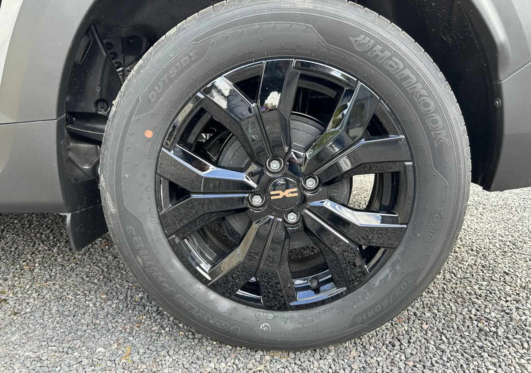 Gros plan sur la jante noire brillante de la roue avant droite du Dacia Jogger gris schiste métal.