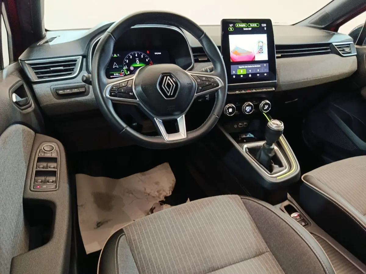 Vue intérieure avant de la Renault Clio Techno TCe 90 2024, volant multifonctions, écran tactile vertical et levier de vitesse manuel.