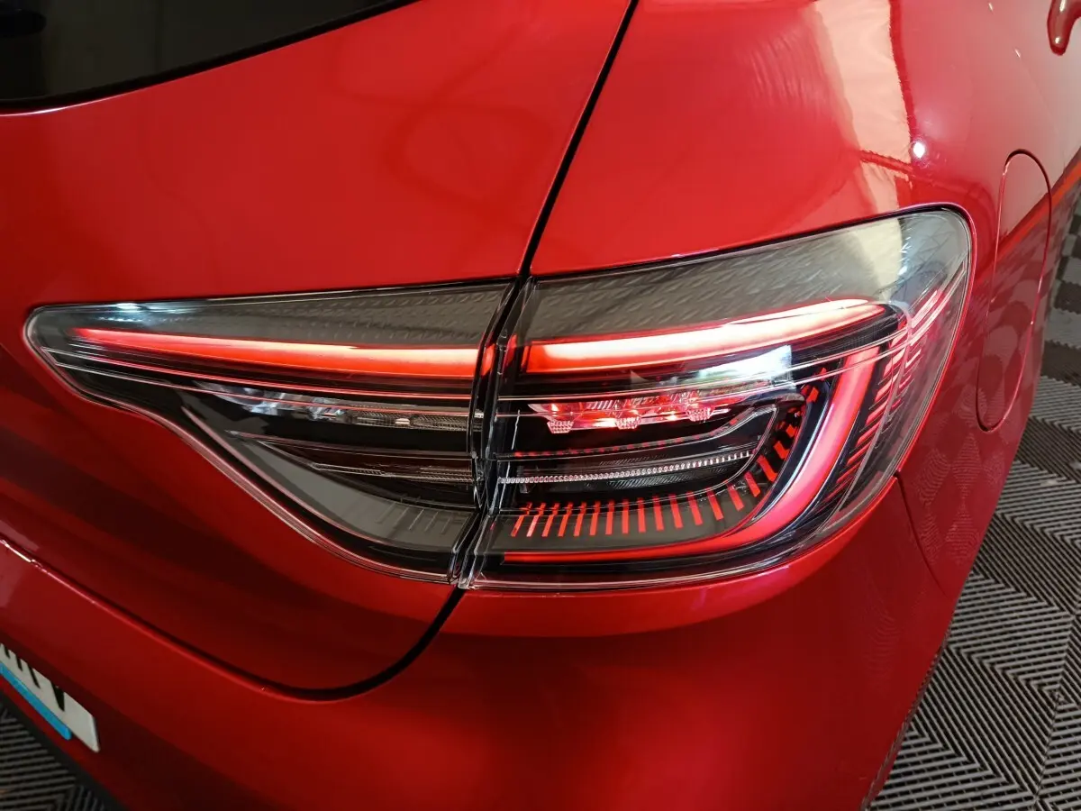 Gros plan sur le feu arrière droit rouge vif d’une Renault Clio 2024 Techno TCe 90, détails LED visibles.