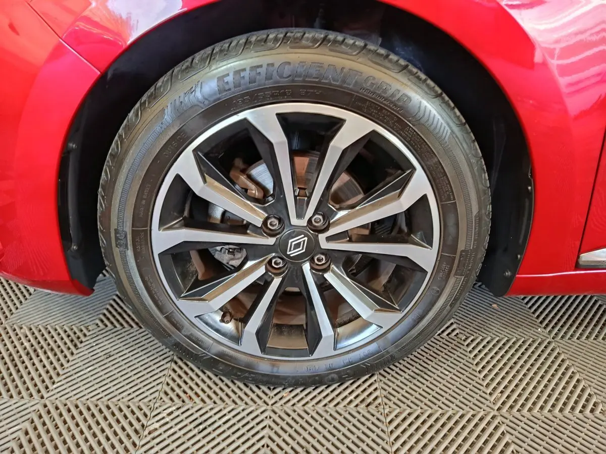Gros plan sur la roue avant droite de la Renault Clio Techno TCe 90 rouge, avec jante alliage noire et argentée.