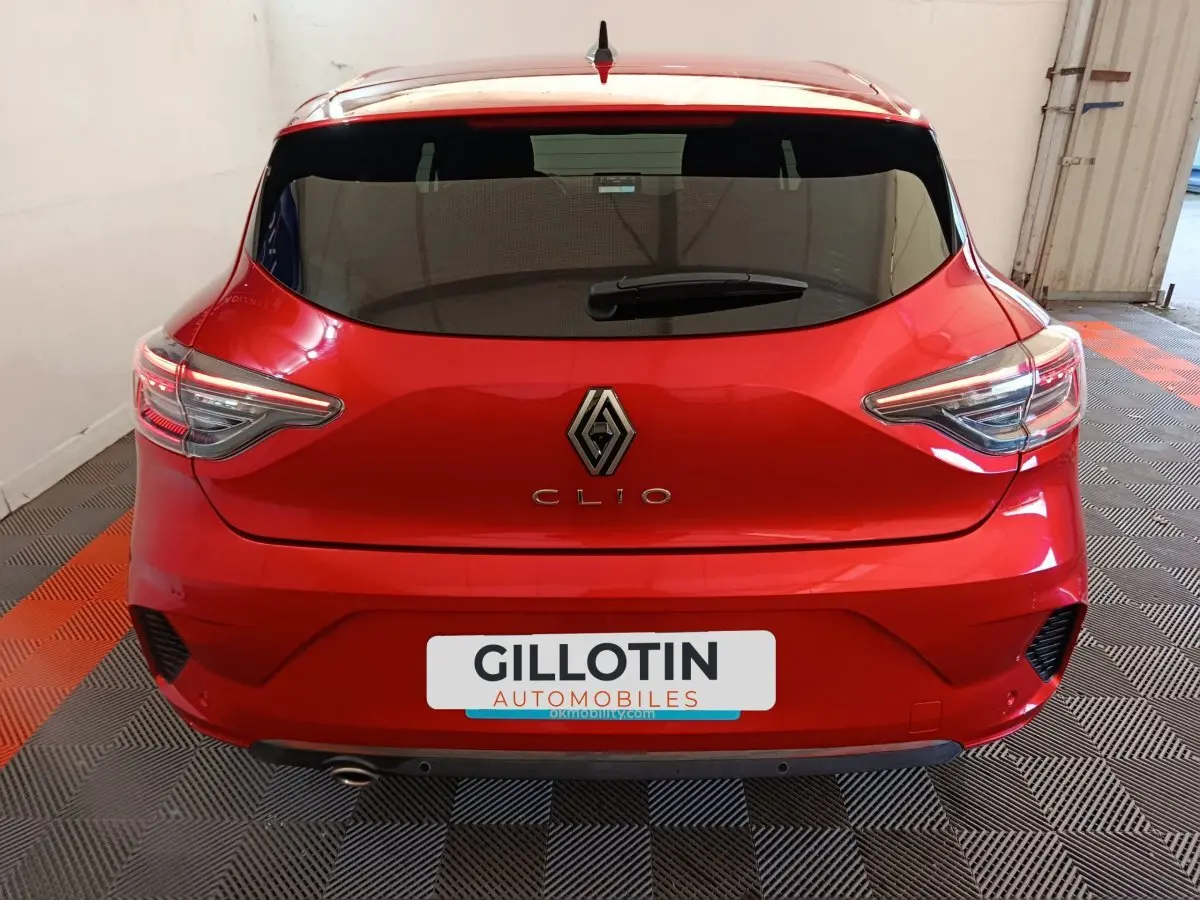 Vue arrière d'une Renault Clio Techno TCe 90 rouge 2024 avec feux LED et lunette arrière teintée.