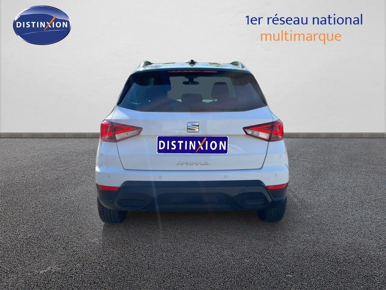 Vue arrière d'un SEAT Arona blanc avec toit gris, mettant en valeur ses feux arrière anguleux et son pare-chocs noir.