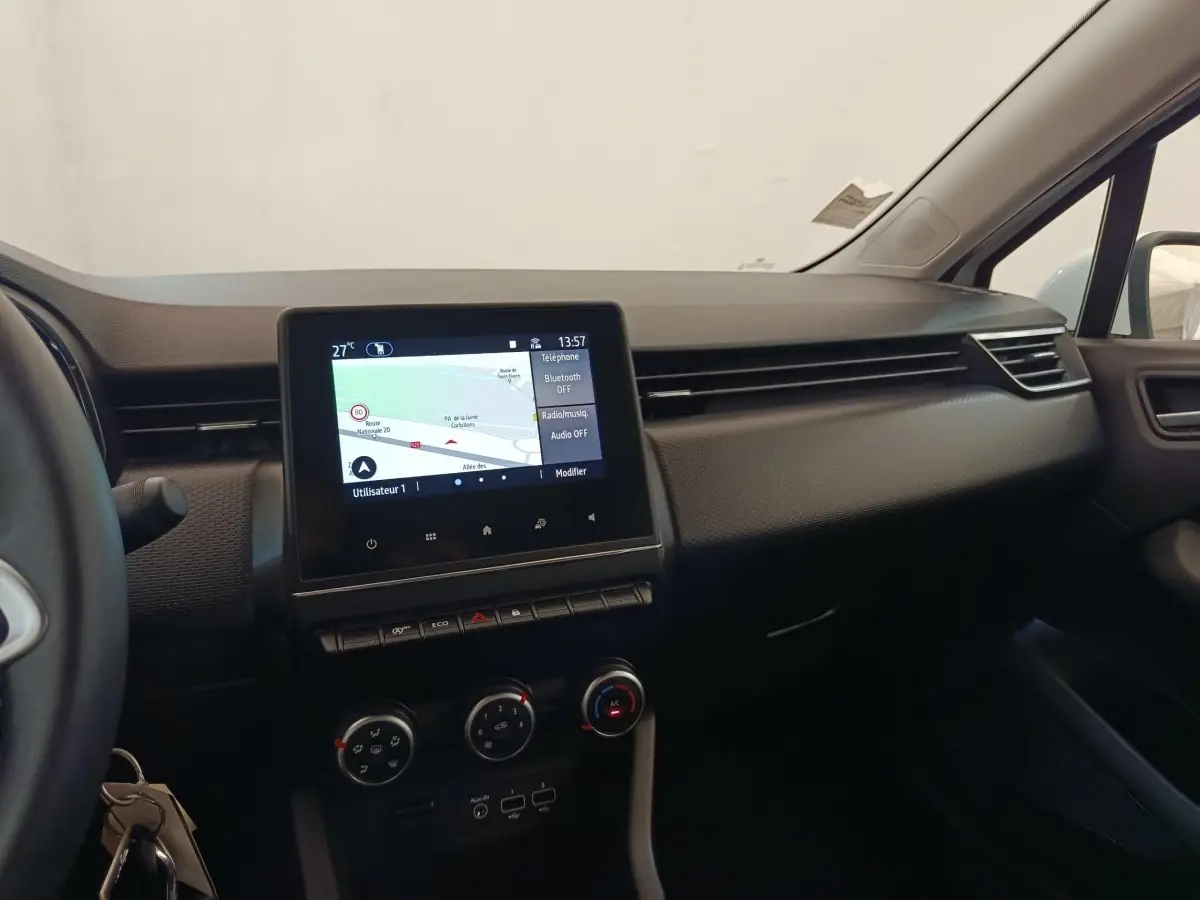 Vue intérieure du tableau de bord de la Renault Clio Business TCe 100 GPL 2021 avec écran tactile central et commandes de climatisation.