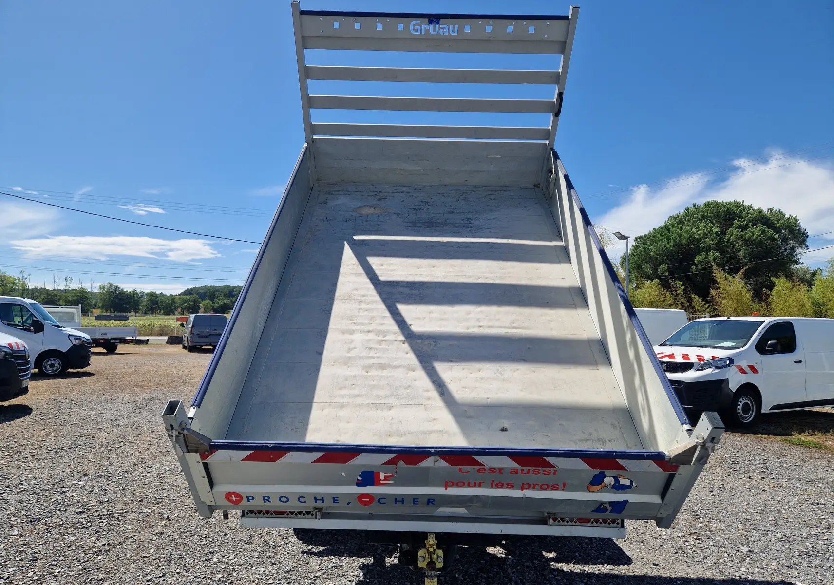 Vue arrière d’une benne relevée blanche sur un Renault Master Châssis Double Cab 2022 avec coffre et marquage réfléchissant.