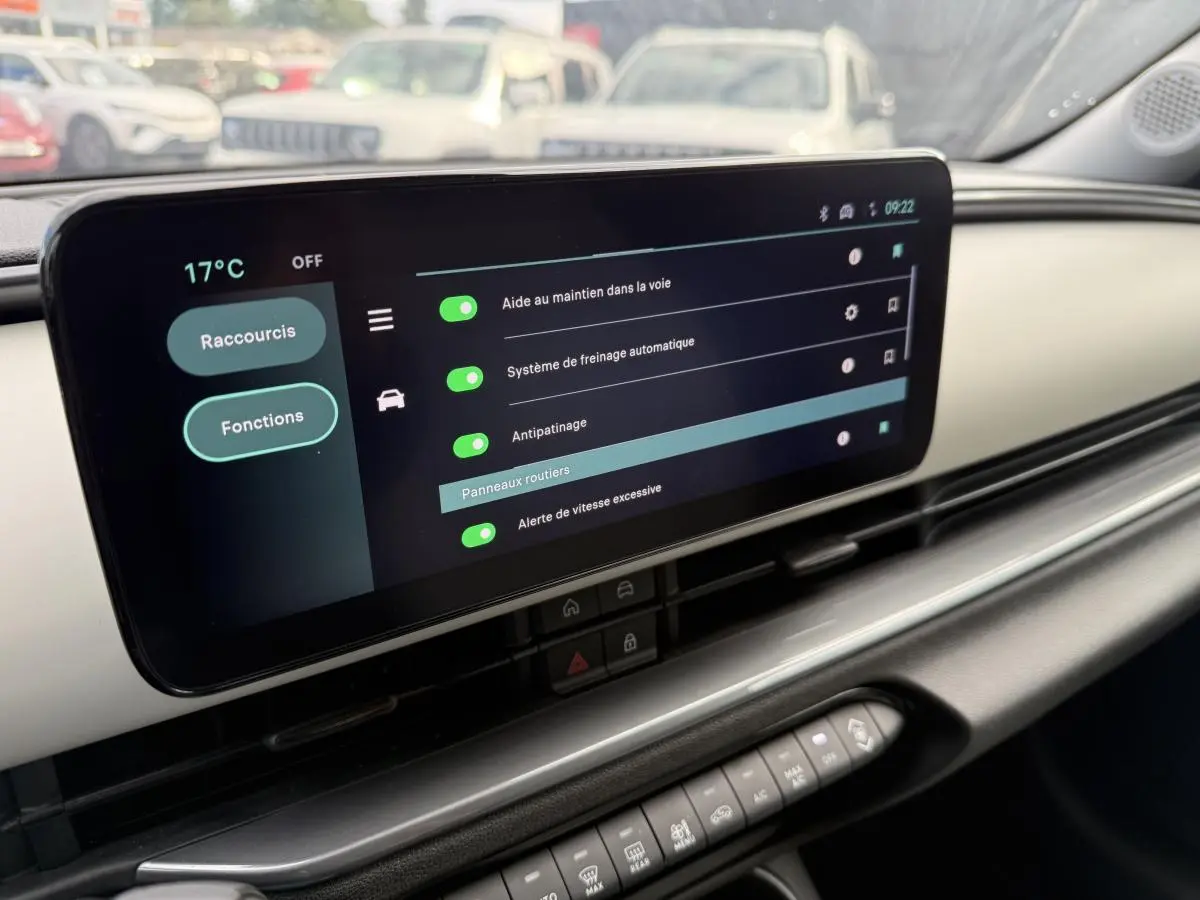 Écran tactile central affichant les aides à la conduite dans l'habitacle ivoire et noir d'une FIAT 600 rouge 2024.