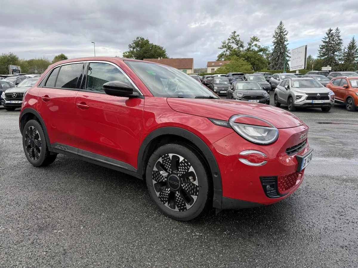 Fiat 600 rouge vue 3/4 avant droit, avec jantes alliage noires et toit noir brillant sur parking humide.