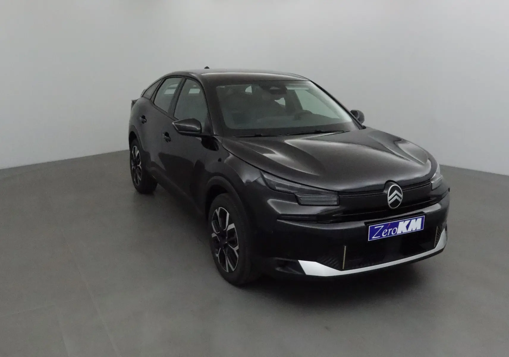 Citroën C4 1.2 Hybrid noir vue 3/4 avant droit dans un studio, avec calandre distinctive et jantes noires.