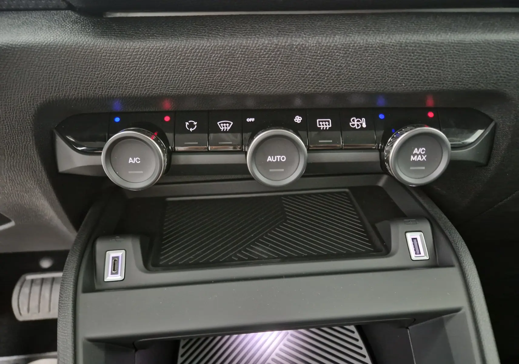 Détail de la console centrale noire du Citroën C4 2025 avec commandes climatisation et ports USB visibles.