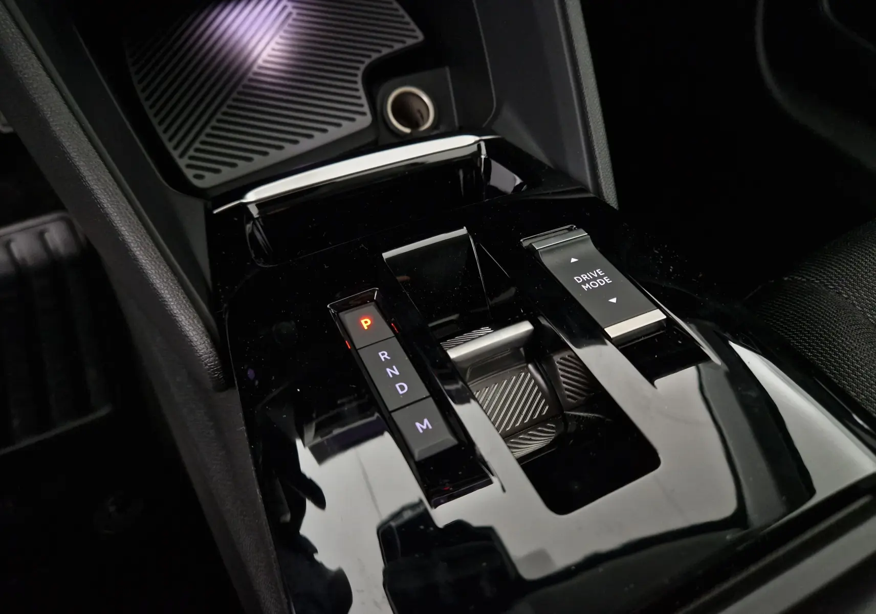 Gros plan sur la console centrale noire de la Citroën C4 1.2 Hybrid 136 e-DSC6 avec levier de vitesses automatique et bouton Drive Mode.