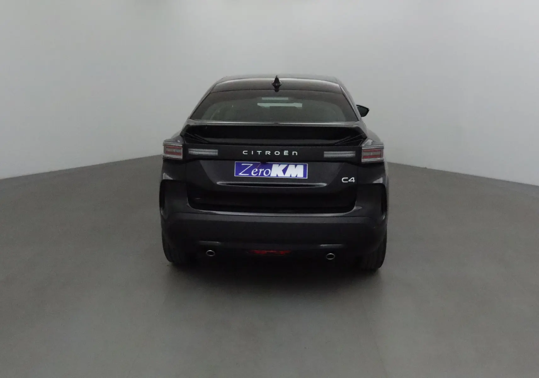Vue arrière du Citroën C4 noir 2025 avec feux horizontaux et double sortie d'échappement visibles.