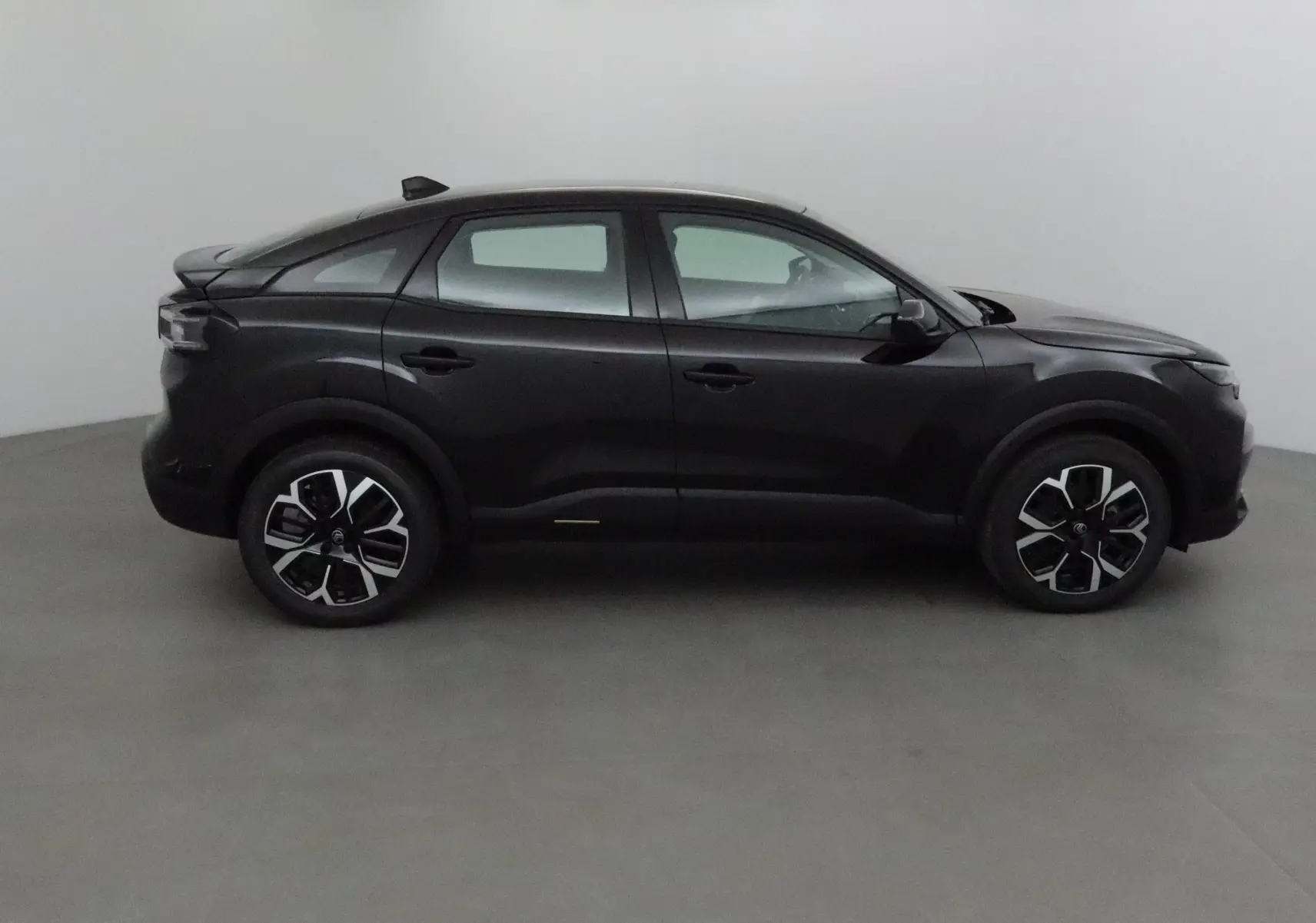 Profil côté gauche d'une Citroën C4 Business Edition noire 2025 avec jantes alliage et toit surélevé.