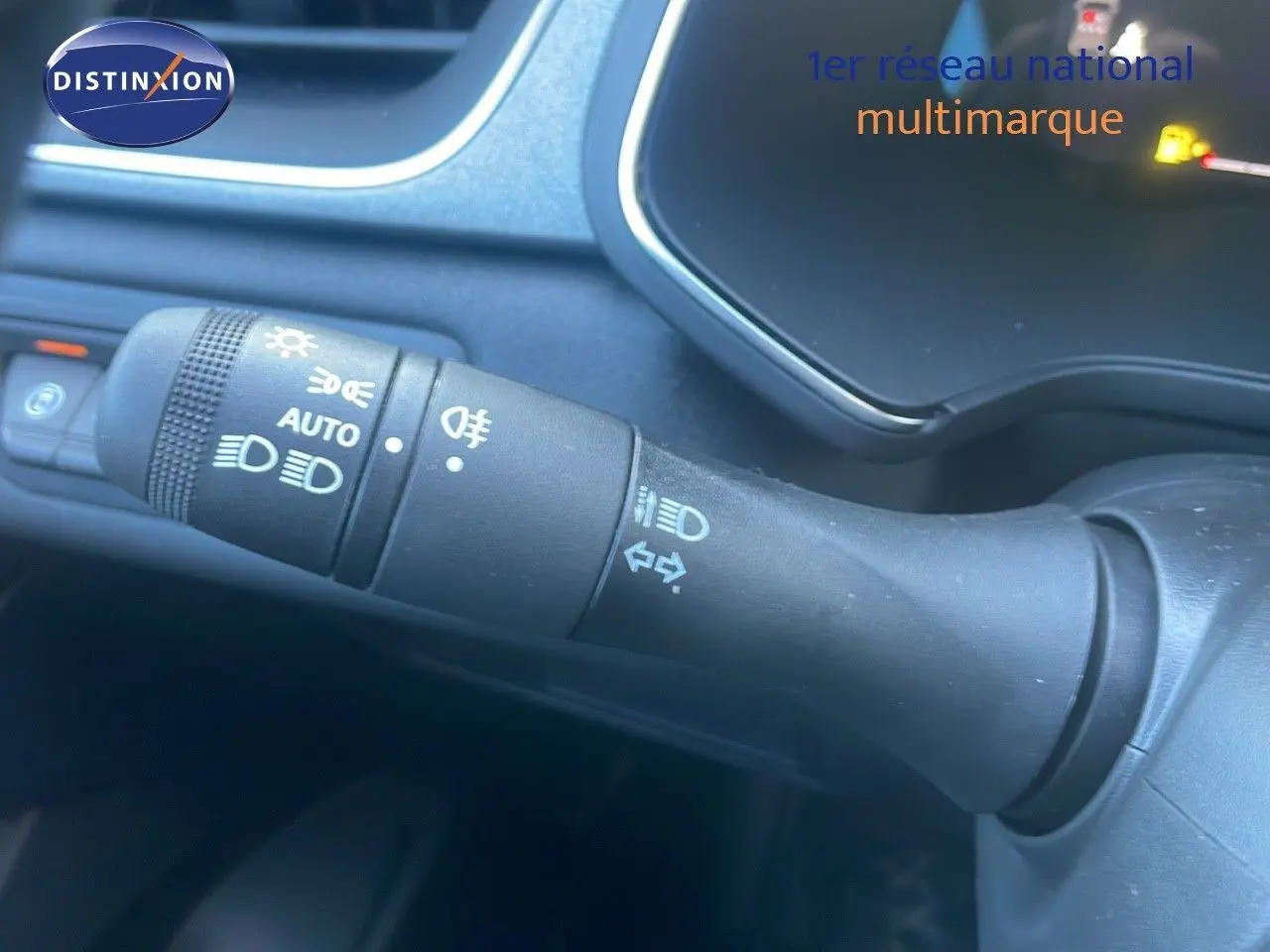 Gros plan sur la commande des feux et clignotants du tableau de bord du Renault Captur noir étoile métal 2025.