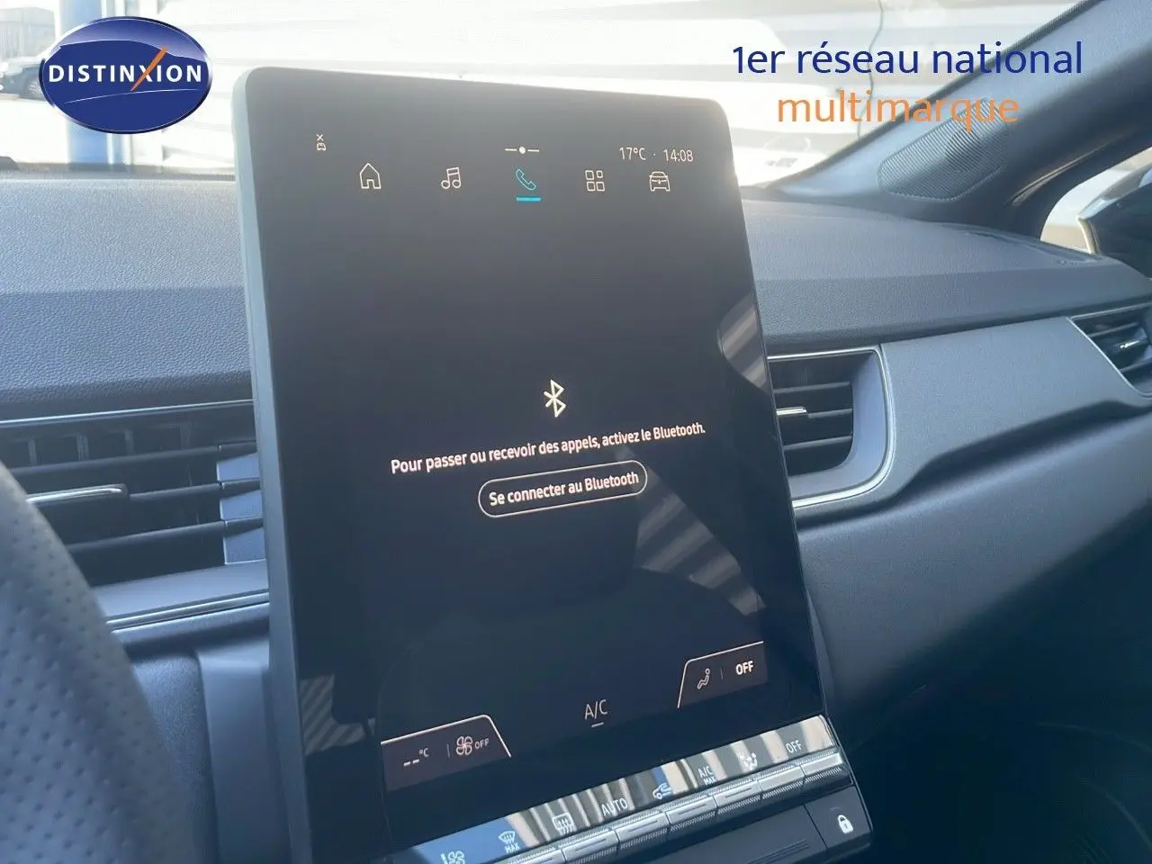 Écran tactile central allumé dans l'habitacle noir du Renault Captur E-Tech Hybrid 2025, vue côté passager.