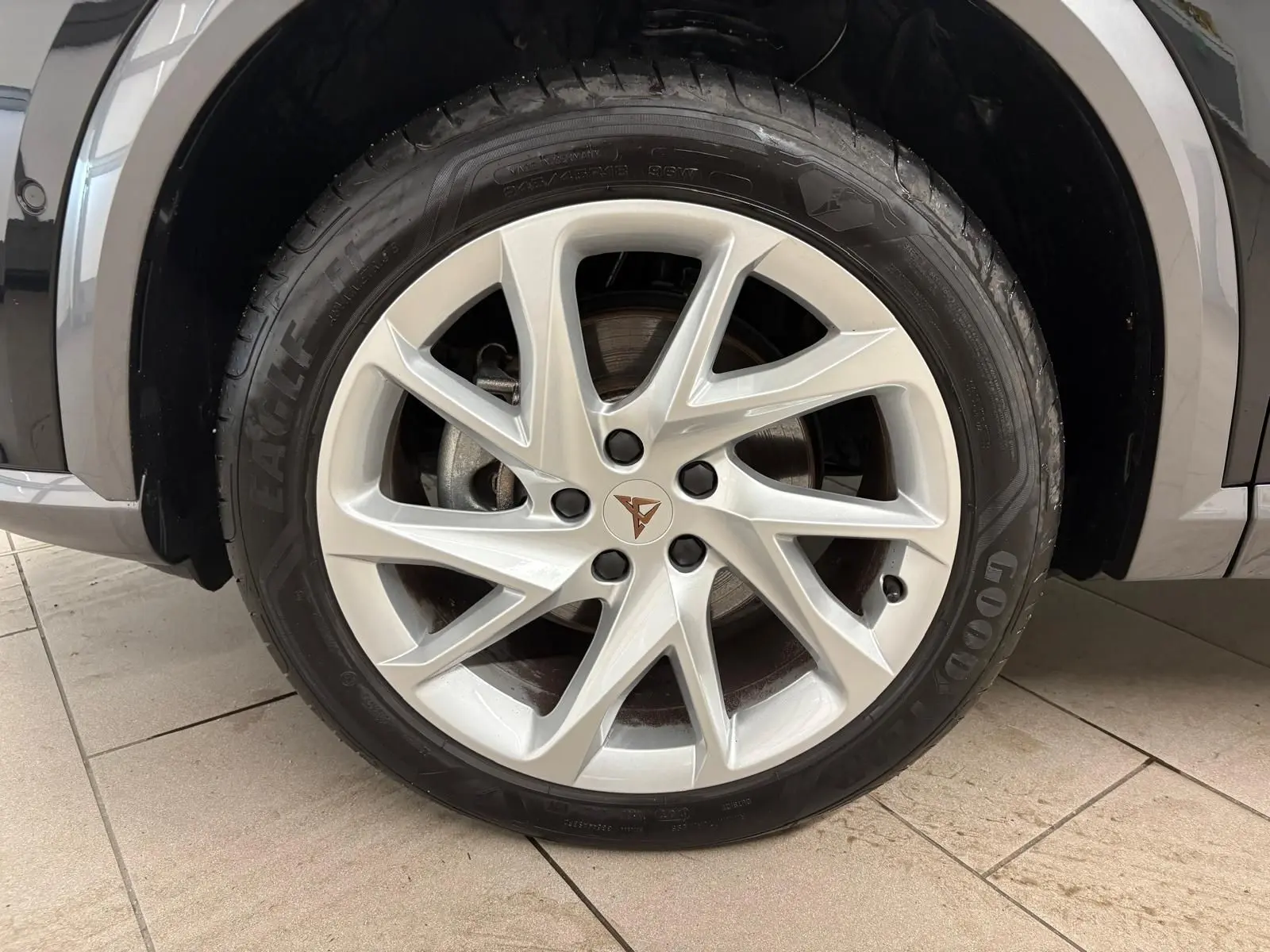 Gros plan sur la roue avant droite du CUPRA Formentor noir minuit, mettant en valeur la jante argentée au design moderne.