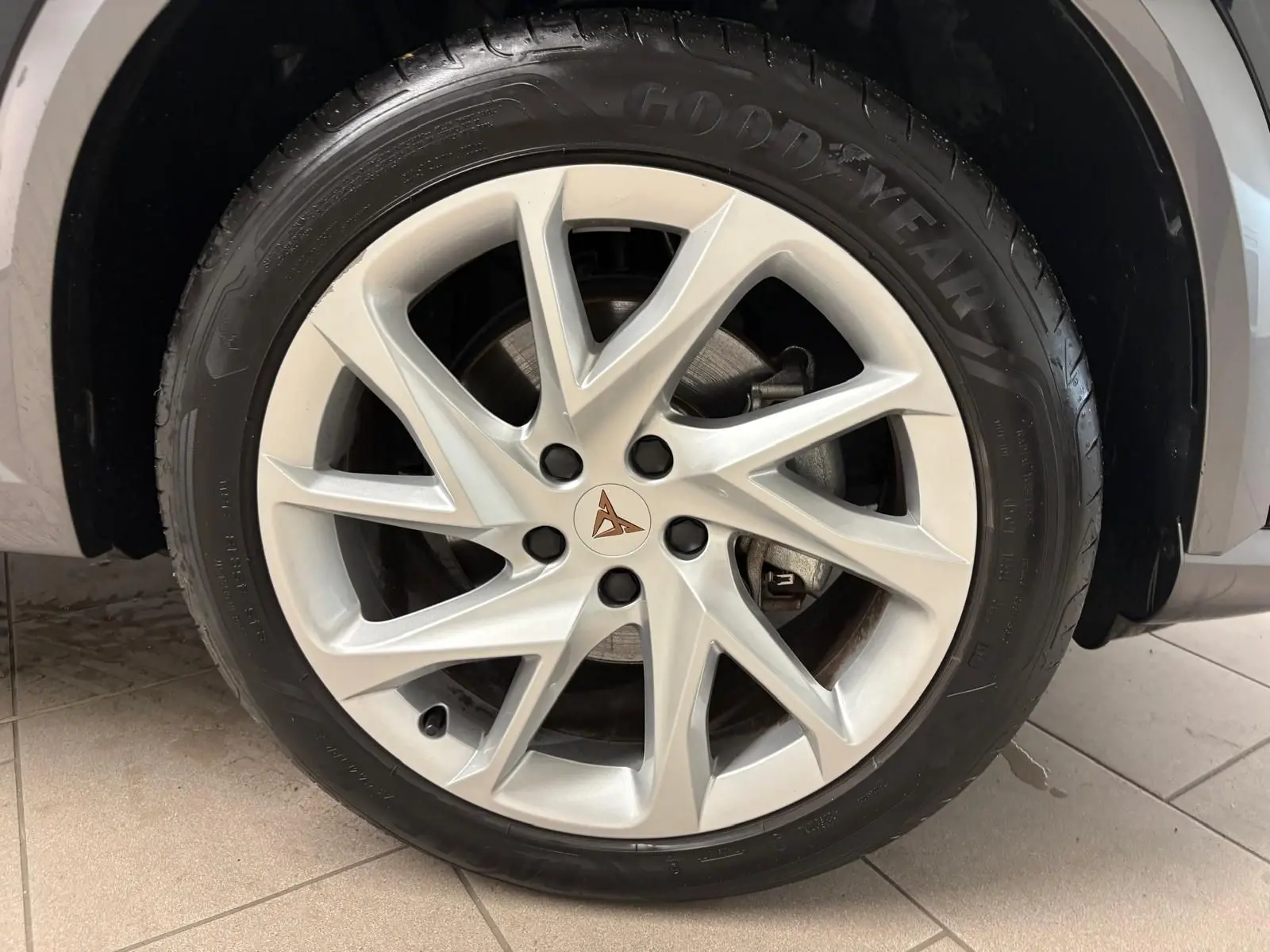 Gros plan sur la jante alliage argentée avec logo CUPRA au centre, montée sur un pneu Goodyear du CUPRA Formentor noir.