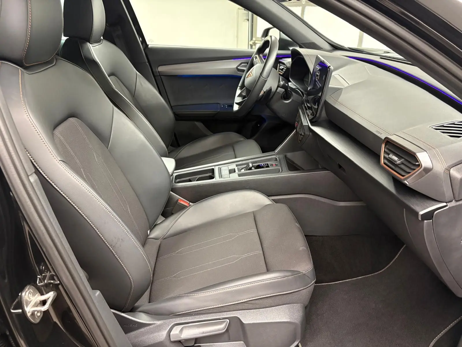 Vue intérieure côté conducteur de la CUPRA Formentor 1.5 TSI 150 DSG7 2024 avec sièges noirs et tableau de bord moderne.