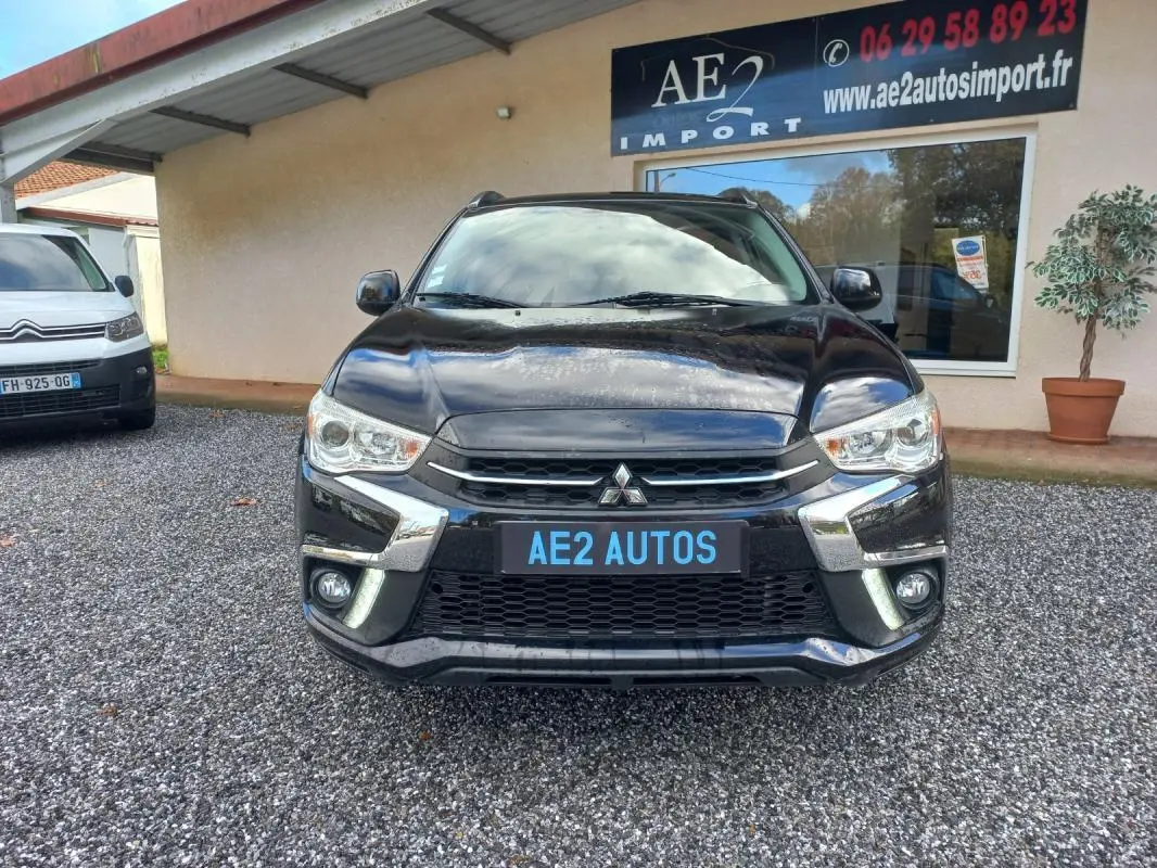 Vue avant d'un Mitsubishi ASX Invite 2WD noir 2020 avec calandre chromée et feux allumés en extérieur.